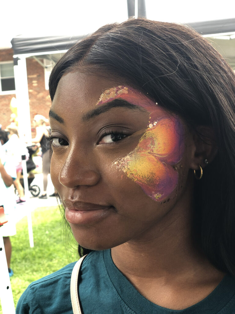 Face painter RI creates a makeup-inspired face art at a neighborhood party