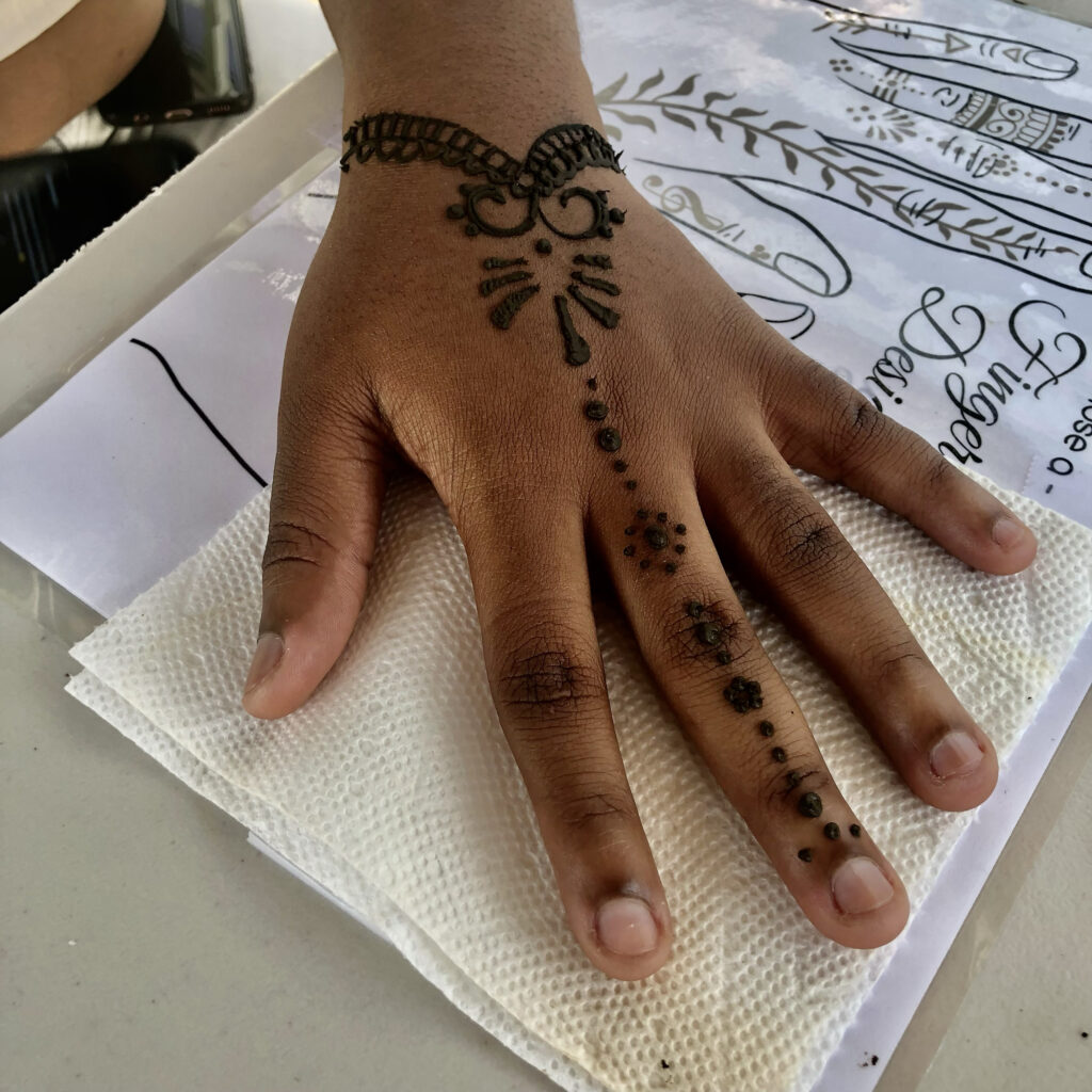 Traditional henna hand design by henna artist RI, displayed on a clean white table