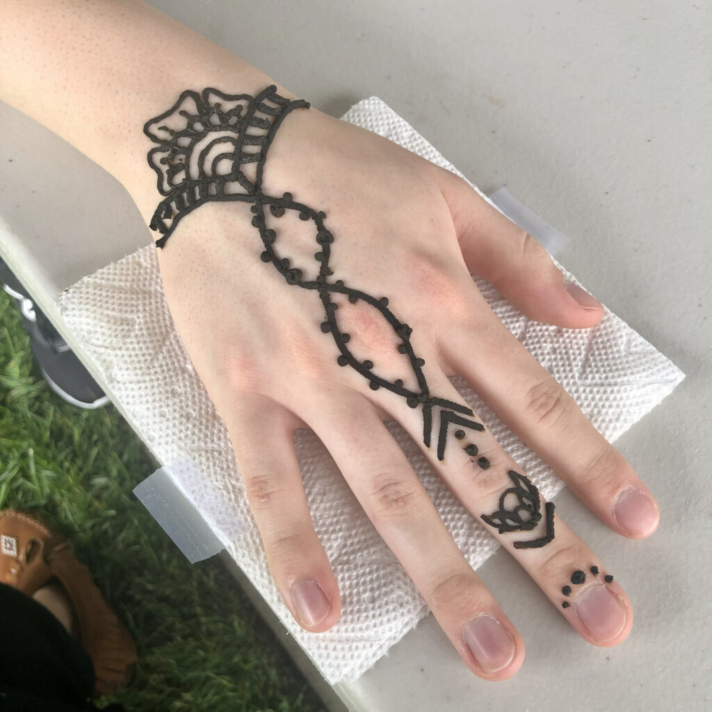 Henna artists RI create detailed jewelry-inspired hand design displayed on a white surface