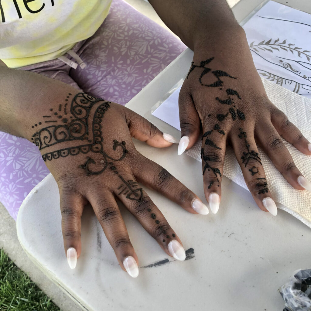 Two hands with a manicure and henna